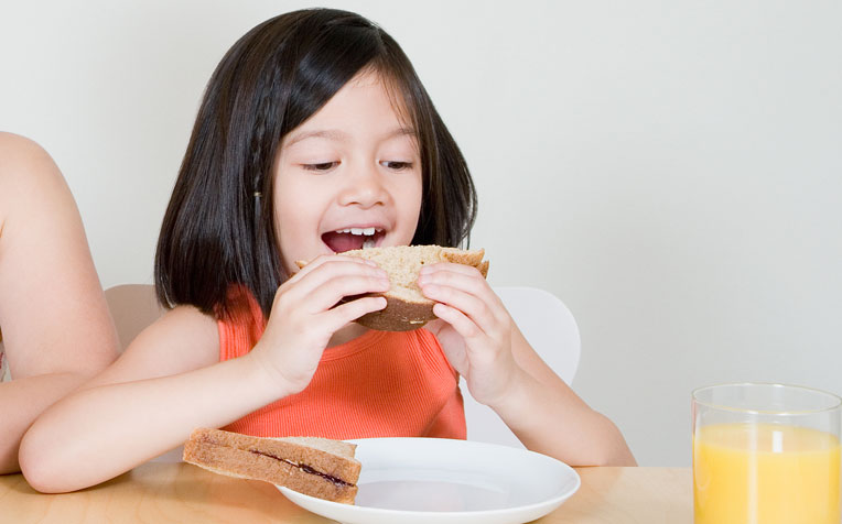 Children should be able to sit down and self-feed, with minimal spillage of solid foods outside the plate, by the age of four.